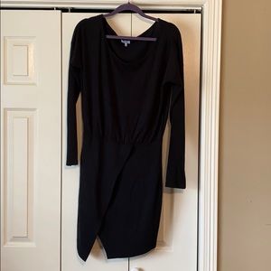 Black sweater dress with asymmetrical slit.